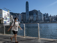 A women wearing a face mask walking pass the Hong Kong Skyline on July 12, 2022 in Hong Kong, China. The Hong Kong Government announce that...