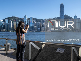 A women taking photos of the Hong Kong Skyline on July 12, 2022 in Hong Kong, China. The Hong Kong Government announce that it would extend...