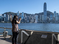 A women taking photos of the Hong Kong Skyline on July 12, 2022 in Hong Kong, China. The Hong Kong Government announce that it would extend...