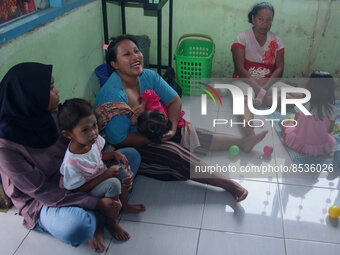 A breastfeeding mother ASI (center) waits for a vaccination queue during the national immunization for children program children at the posy...