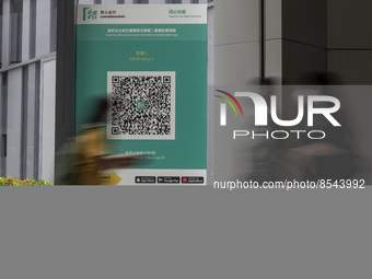 A Long Exposure photo of People walking pass a Leave Home Safe QR code placed on a window at the entrance of a shopping mall on July 15, 202...