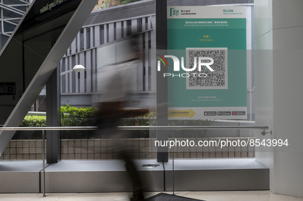 A Long Exposure photo of People walking pass a Leave Home Safe QR code placed on a window at the entrance of a shopping mall on July 15, 202...