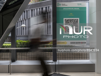 A Long Exposure photo of People walking pass a Leave Home Safe QR code placed on a window at the entrance of a shopping mall on July 15, 202...