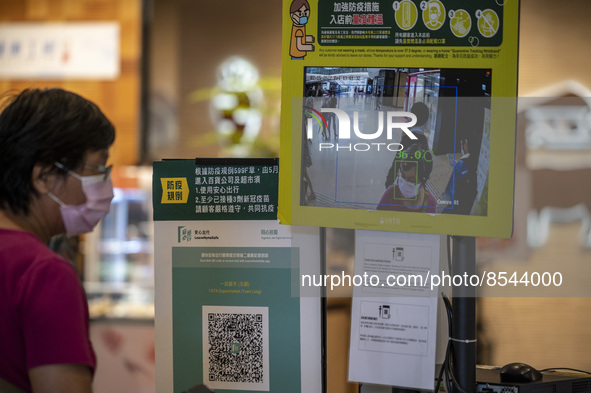 The Leave Home Safe QR code and a temperature check point placed at the entrance of a store inside a shopping mall on July 15, 2022 in Hong...