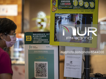 The Leave Home Safe QR code and a temperature check point placed at the entrance of a store inside a shopping mall on July 15, 2022 in Hong...