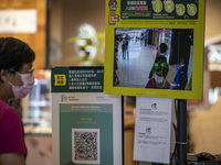 The Leave Home Safe QR code and a temperature check point placed at the entrance of a store inside a shopping mall on July 15, 2022 in Hong...