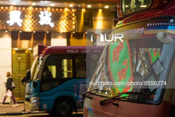 Hong Kong, China, 3 Jul 2022, A LED sign can be seen reflected in the windshield of a red minibus. 