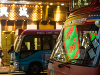 Hong Kong, China, 3 Jul 2022, A LED sign can be seen reflected in the windshield of a red minibus. (