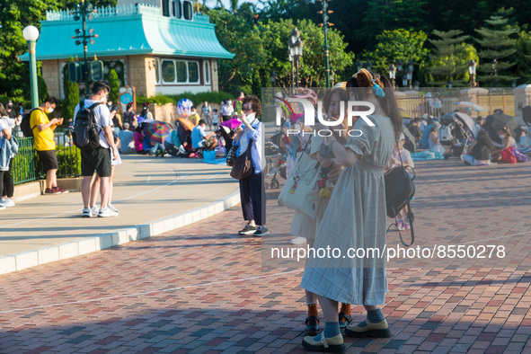 Hong Kong, China, 10 Jul 2022, Young ladies take selfies unmasked before the Hong Kong Disneyland castle. 