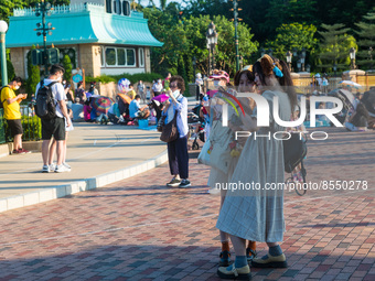 Hong Kong, China, 10 Jul 2022, Young ladies take selfies unmasked before the Hong Kong Disneyland castle. (