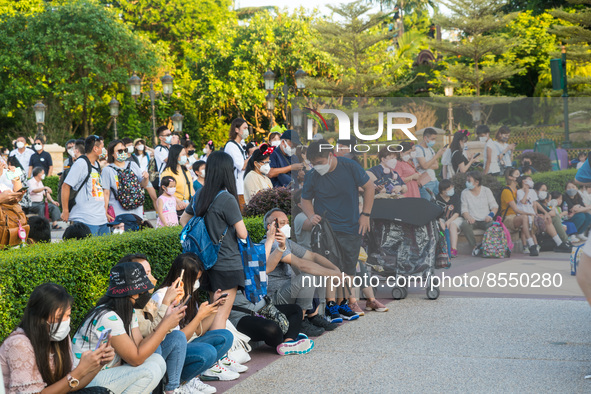 Hong Kong, China, 10 Jul 2022, People sit down in front of the Hong Kong Disneyland castle, waiting for a show to start. 