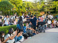 Hong Kong, China, 10 Jul 2022, People sit down in front of the Hong Kong Disneyland castle, waiting for a show to start. (