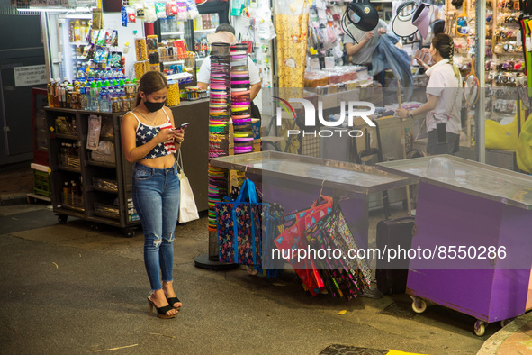 Hong Kong, China, 15 Jul 2022, A young lady checks her phone in Causeway Bay. 