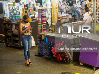 Hong Kong, China, 15 Jul 2022, A young lady checks her phone in Causeway Bay. (