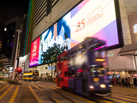 Hong Kong, China, 15 Jul 2022, A tramway passes in Causeway Bay in front of an electronic billboard celebrating the 25th anniversary of the...