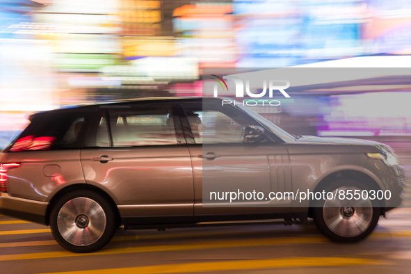 Hong Kong, China, 15 Jul 2022, A Range Rover SUV passes in Causeway Bay in this panned shot. 