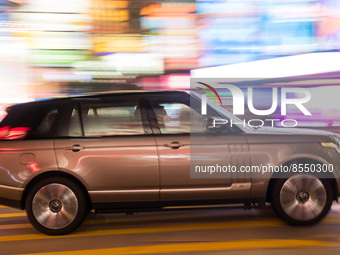 Hong Kong, China, 15 Jul 2022, A Range Rover SUV passes in Causeway Bay in this panned shot. (