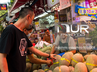 Hong Kong, China, 16 Jul 2022, Customers check melons at a fruit shop in Yuen Long. (