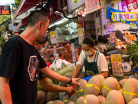 Hong Kong, China, 16 Jul 2022, Customers check melons at a fruit shop in Yuen Long. (