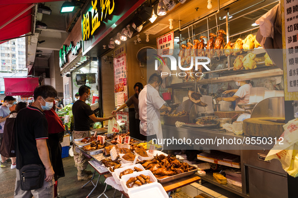 Hong Kong, China, 16 Jul 2022, Customers buy roast goose or chicken at a shop in Yuen Long. 