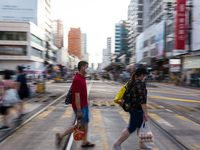 Hong Kong, China, 16 Jul 2022, People cross Castle Peak road in Yuen Long. (