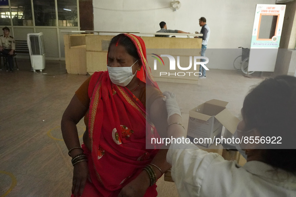 A woman reacts as a health worker inoculates her during a vaccination drive against coronavirus, at a hospital in Noida on the outskirts of...