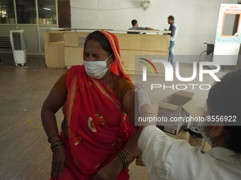 A woman reacts as a health worker inoculates her during a vaccination drive against coronavirus, at a hospital in Noida on the outskirts of...