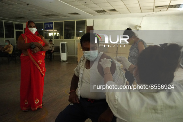 A man reacts as a health worker inoculates him during a vaccination drive against coronavirus, at a hospital in Noida on the outskirts of Ne...