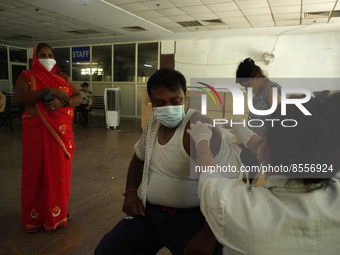 A man reacts as a health worker inoculates him during a vaccination drive against coronavirus, at a hospital in Noida on the outskirts of Ne...