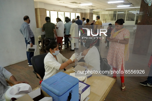 A man wearing a helmet gets inoculated during a vaccination drive against coronavirus, at a hospital in Noida on the outskirts of New Delhi,...