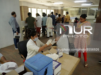 A man wearing a helmet gets inoculated during a vaccination drive against coronavirus, at a hospital in Noida on the outskirts of New Delhi,...