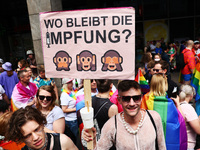 A man holds a banner reading 'Where is the vaccination?' during the Christopher Street Day demonstration in Berlin, Germany on July 23, 2022...