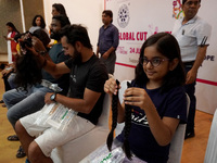 Volunteers show their locks of hair donated to cancer patients during 'Hair for Hope-India's donation drive held as part of an awareness cam...