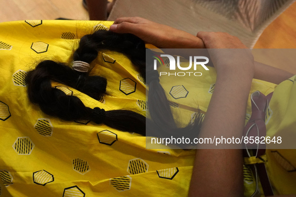 A girl with her locks of hair donated to cancer patients during 'Hair for Hope-India's donation drive held as part of an awareness campaign,...