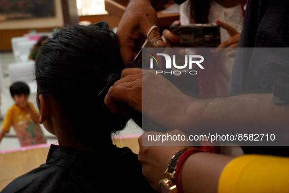 A hairdresser cuts the hair of a donor during 'Hair for Hope-India's donation drive for cancer survivors held as part of an awareness campai...