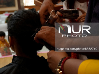 A hairdresser cuts the hair of a donor during 'Hair for Hope-India's donation drive for cancer survivors held as part of an awareness campai...