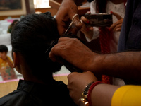 A hairdresser cuts the hair of a donor during 'Hair for Hope-India's donation drive for cancer survivors held as part of an awareness campai...