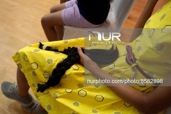 A young girl holds her locks of hair after snipping off for donating to cancer patients during 'Hair for Hope-India' donation drive held as...