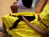 A young girl holds her locks of hair after snipping off for donating to cancer patients during 'Hair for Hope-India' donation drive held as...