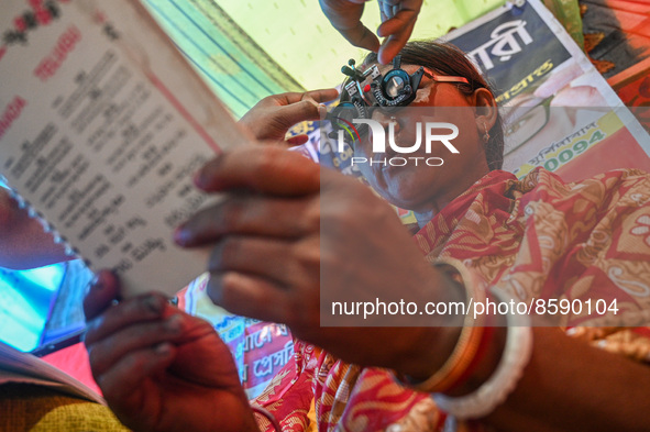 A woman reads a booklet during a free eye-testing camp at Kumirmari village, in the Sundarbans, on July 26, 2022. The camp was organised by...