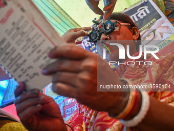 A woman reads a booklet during a free eye-testing camp at Kumirmari village, in the Sundarbans, on July 26, 2022. The camp was organised by...