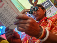 A woman reads a booklet during a free eye-testing camp at Kumirmari village, in the Sundarbans, on July 26, 2022. The camp was organised by...