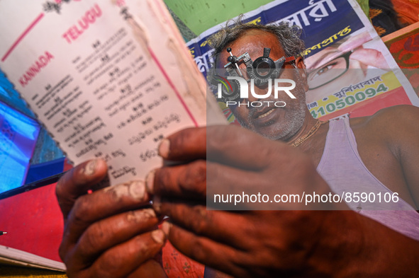 A man reads a booklet during a free eye-testing camp at Kumirmari village, in the Sundarbans, on July 26, 2022. The camp was organised by a...