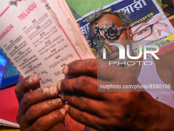 A man reads a booklet during a free eye-testing camp at Kumirmari village, in the Sundarbans, on July 26, 2022. The camp was organised by a...