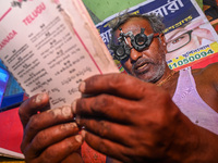 A man reads a booklet during a free eye-testing camp at Kumirmari village, in the Sundarbans, on July 26, 2022. The camp was organised by a...