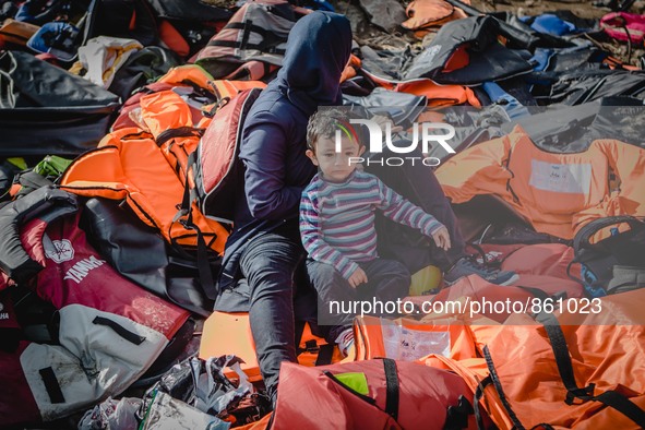 A women takes off her lifejacket in a pile of old lifejackets on the island of Lesbos, Greece, on September 26, 2015. 