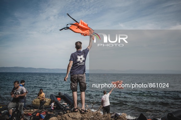 Volunteers waves lifejackets to direct boats to the safe areas to land on the shores of Lesbos, Greece, on September 26, 2015.  