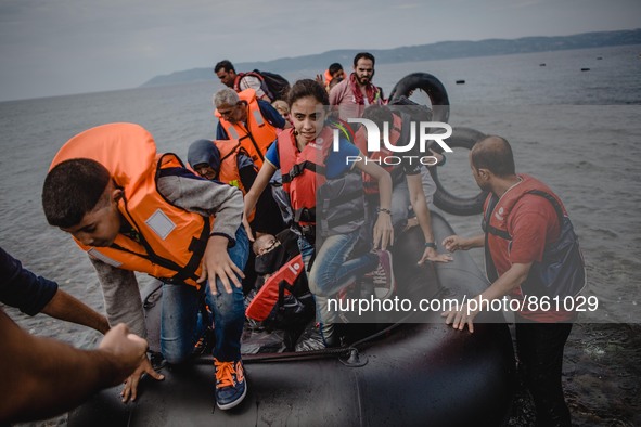 Migrants rush off the dinghy they cross the sea with once they arrive in Lesbos, Greece, Greece, on September 26, 2015.  