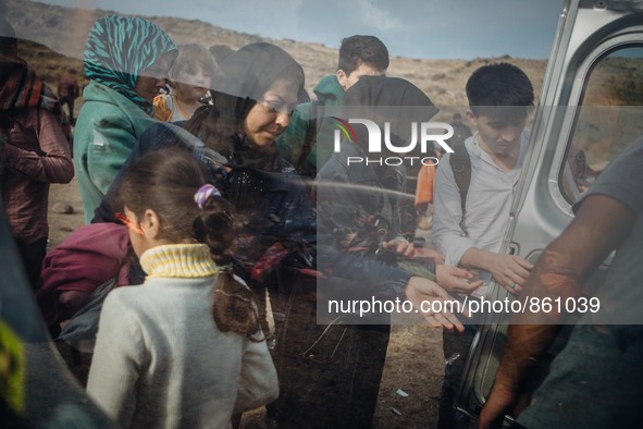 Volunteers hand out water to newly arrived refugees once they get off the boats from the Turkish coast, on September 27, 2015.  