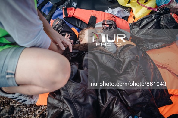 A baby lies on life jackets on the shore of Lesbos, Greece, on September 27, 2015.  